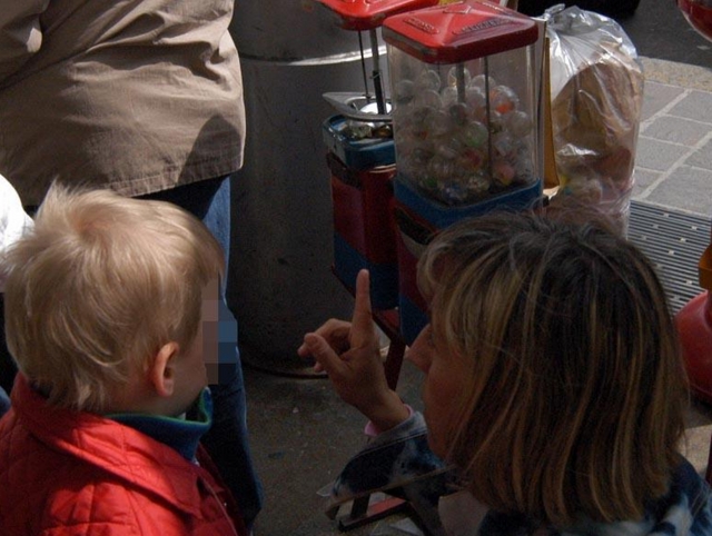 Bimbo con mano incastratanel distributore di palline