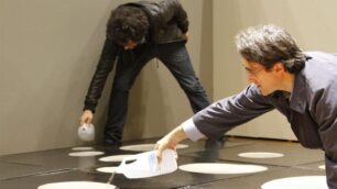 Daniele Astrologo Abadal mentre riempie d’acqua “9 mq di pozzanghere” di Pino Pascali a”Prima che il gallo canti”, nel 2011 all’arengario di Monza