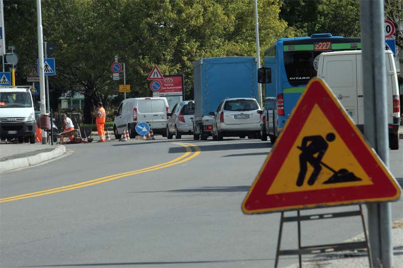 Code di auto in via Pergolesi per la posa dei semafori nuovi (Foto Radaelli)