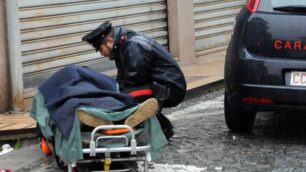 Un carabiniere davanti alla barella con il rapinatore ferito