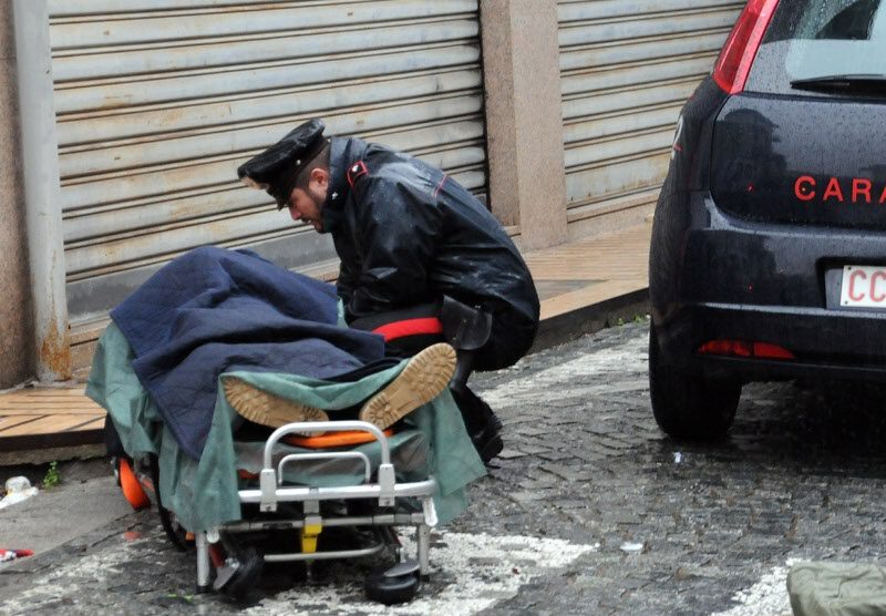 Un carabiniere davanti alla barella con il rapinatore ferito