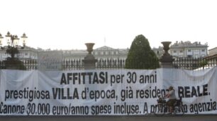 Il primo striscione beffa contro la cessione ai privati della Villa reale, messo sui cancelli della reggia di Monza nel 2011