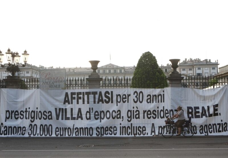 Il primo striscione beffa contro la cessione ai privati della Villa reale, messo sui cancelli della reggia di Monza nel 2011