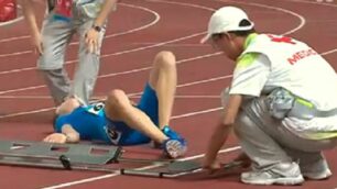 Filippo Tortu a terra sulla pista di Nanjing.