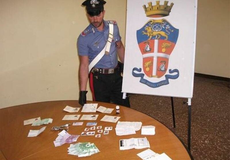 Un carabiniere mostra le carte di credito e di identità trovate nell’auto
