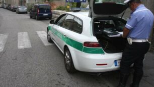 Un agente della polizia locale di Monza impegnato in un rilevamento dopo un incidente stradale