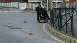 La sedia a rotelle rimasta bloccata in mezzo alla strada
