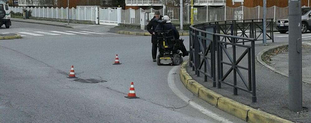 La sedia a rotelle rimasta bloccata in mezzo alla strada