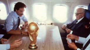 La storica partita a scopone tra Zoff, Causio, Pertini e Bearzot sull’aereo che sta riportando in Italia la nazionale di calcio. In primo piano, la Coppa del Mondo appena vinta