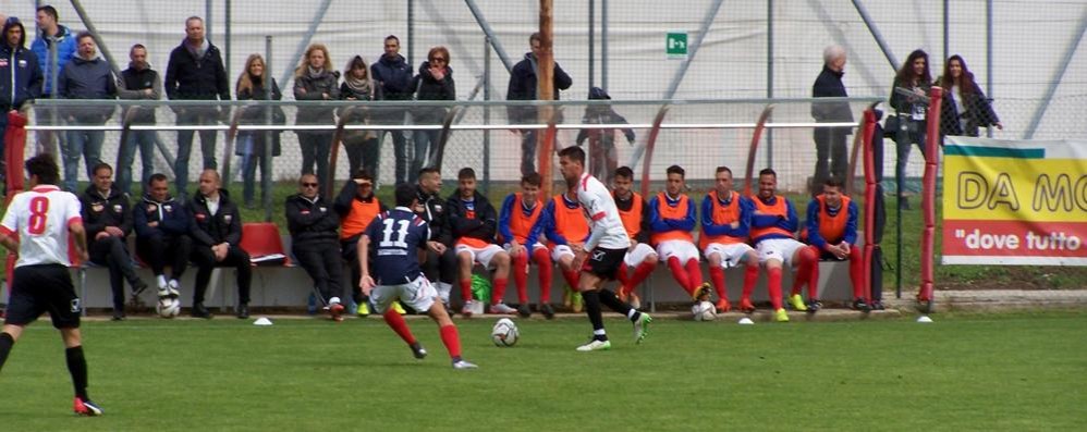 Calcio, Thomas Capelli del Seregno contrastato dalla punta di casa Nicolò Oldrini davanti alla panchina della Varesina