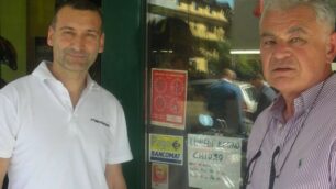 Maurizio Gloriotti davanti al suo negozio di Limbiate insieme a un altro negoziante