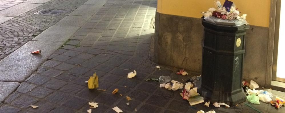 Monza, la foto scattata da un lettore sabato sera vicino all’arengario: un cestino straripante di rifiuti