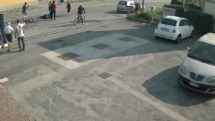 Il ciclista a terra e sulla destra la Punto grigia con il bambino sceso a guardare. Al centro,  la automobilista pirata