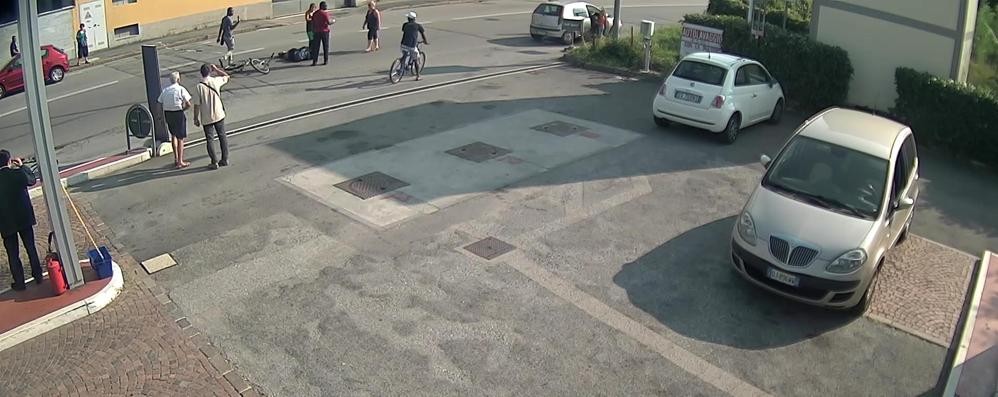 Il ciclista a terra e sulla destra la Punto grigia con il bambino sceso a guardare. Al centro,  la automobilista pirata