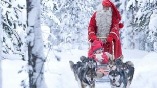 Un bambino in slitta con Babbo Natale