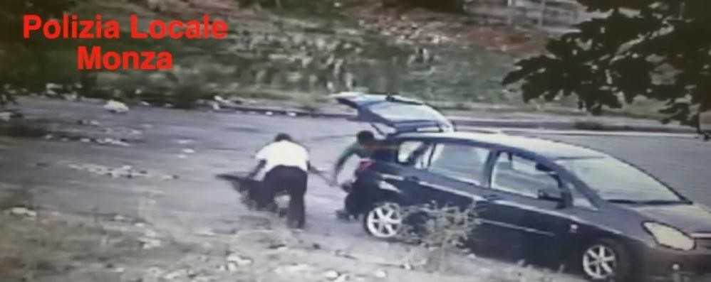 I due stranieri intenti a gettare i rifiuti per strada