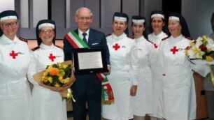 Il commissario Zanzi consegna il “Premio Mimosa 2018”: Maria Carla Pellegatta  è la crocerossina con in mano il mazzo di fiori.
