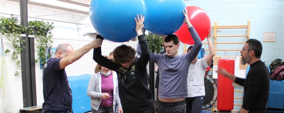 Un gruppo di ragazzi in palestra mentre eseguono il "percorso sensoriale psicomotorio" ( foto Volonterio)