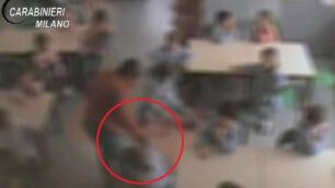 Un fermo immagine del filmato diffuso dai  carabinieri: nel cerchio si nota la mano della maestra afferrare i capelli di una bambina