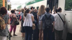 Pendolari in stazione a Lissone con il treno stracarico