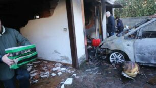 L’auto distrutta dalle fiamme e i tre box crollati