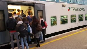 Pendolari e studenti cercano di trovare posto su un treno di Trenord