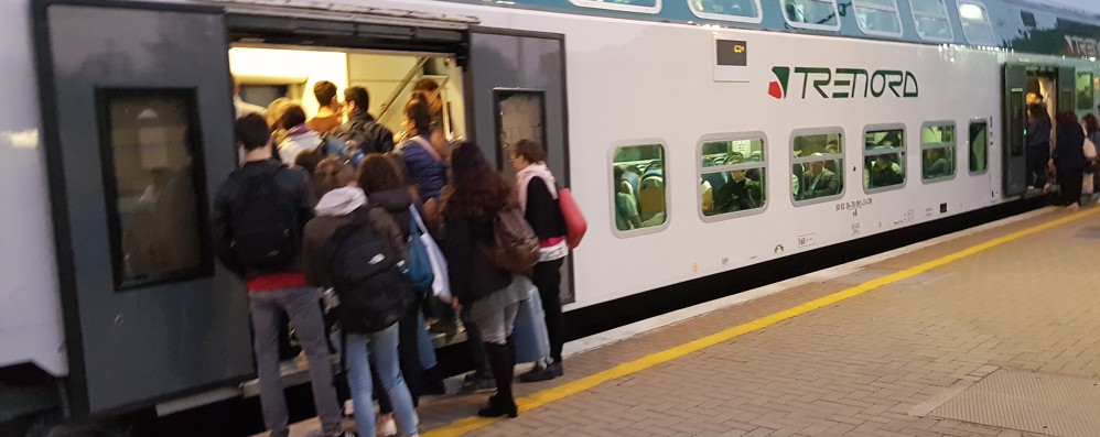 Pendolari e studenti cercano di trovare posto su un treno di Trenord