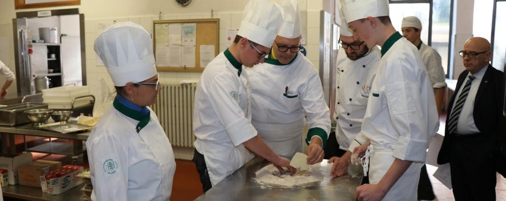 Docenti e studenti dell'alberghiero Ballerini mentre preparano il "pane della memoria " ( foto Volonterio)