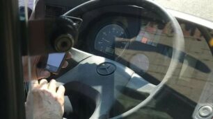 L’autista mentre guarda il cellulare nelle foto scattate da una giovane utente