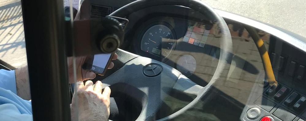 L’autista mentre guarda il cellulare nelle foto scattate da una giovane utente