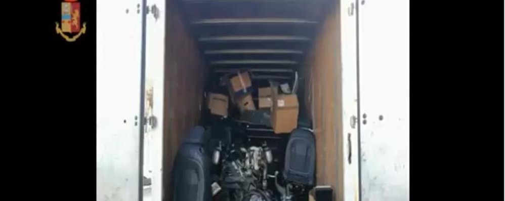 Sedili, un motore e altri pezzi di una vettura cannibalizzata caricati su un camion