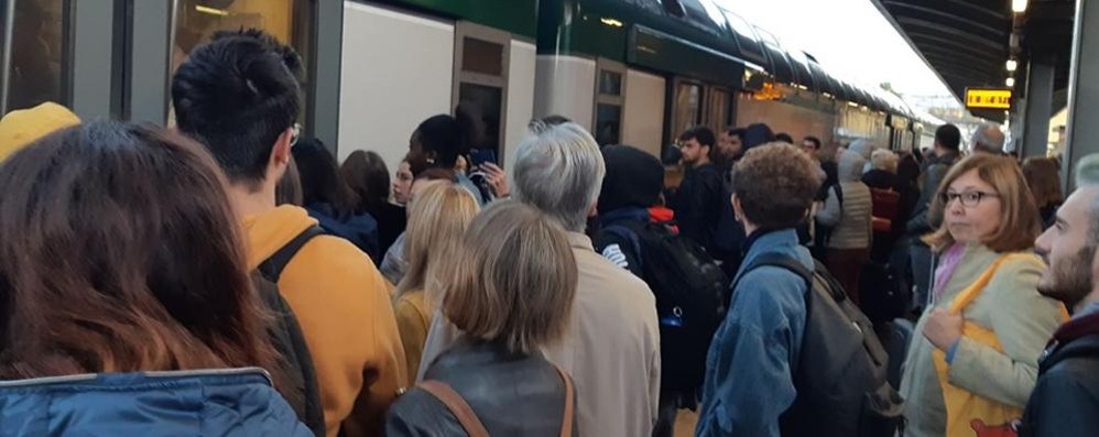 Pendolari in attesa davanti a un treno guasto