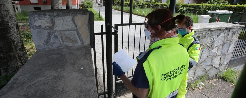 La Protezione civile di Monza mentre consegna buoni spesa e mascherine