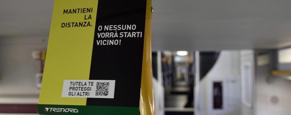 Un avviso per la prevenzione Covid-19 su un convoglio di Trenord