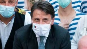 Conte in piazza con la mascherina a un evento estivo