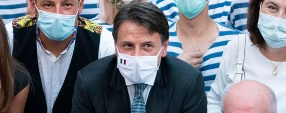 Conte in piazza con la mascherina a un evento estivo