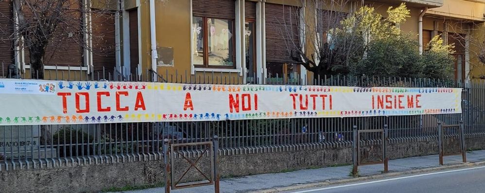 Albiate striscione e scuola dell'infanzia paritaria per visita Delpini