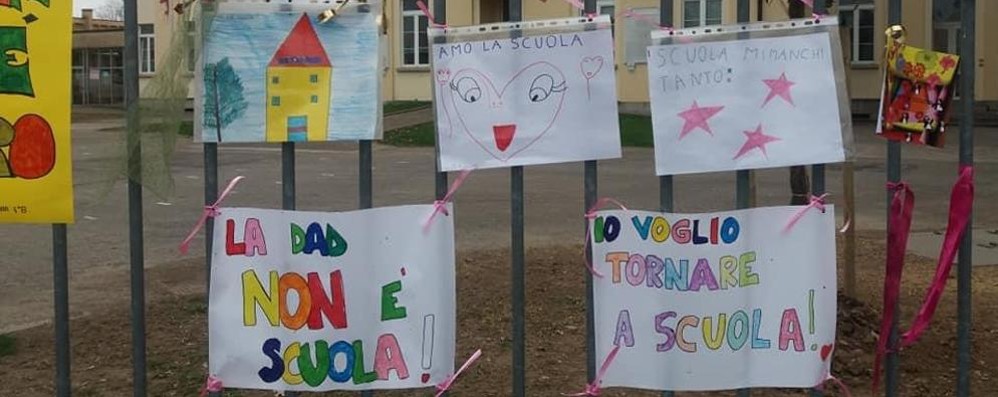 I cartelli appesi sul cancello della scuola