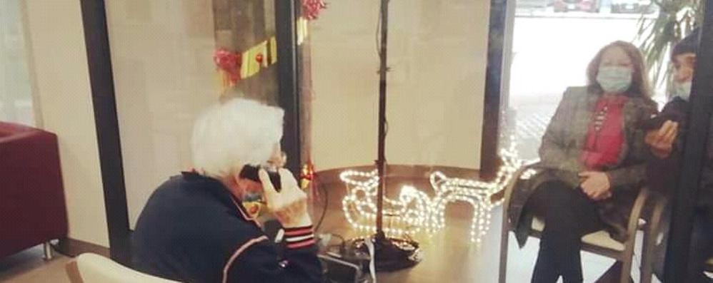 Una telefonata attraverso il vetro nel periodo natalizio alla rsa di Cesano Maderno