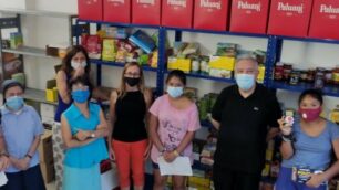 I volontari nel magazzino alimentare, con l'assessore alle Politiche sociali Laura Capelli e Monsignor Bruno Molinari, Prevosto di Seregno