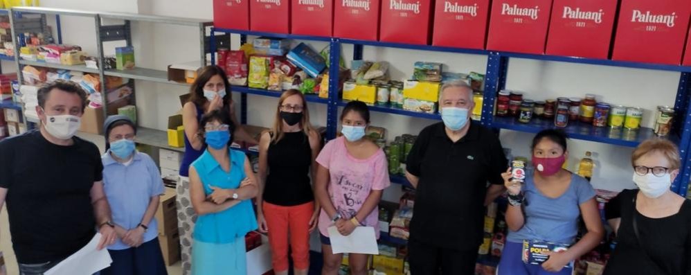 I volontari nel magazzino alimentare, con l'assessore alle Politiche sociali Laura Capelli e Monsignor Bruno Molinari, Prevosto di Seregno