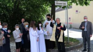 Il prevosto monsignor Bruno Molinari mentre benedici largo Colli con a fianco il sindaco Rossi, don De Col e i familiari di Colli ( foto Volonterio)