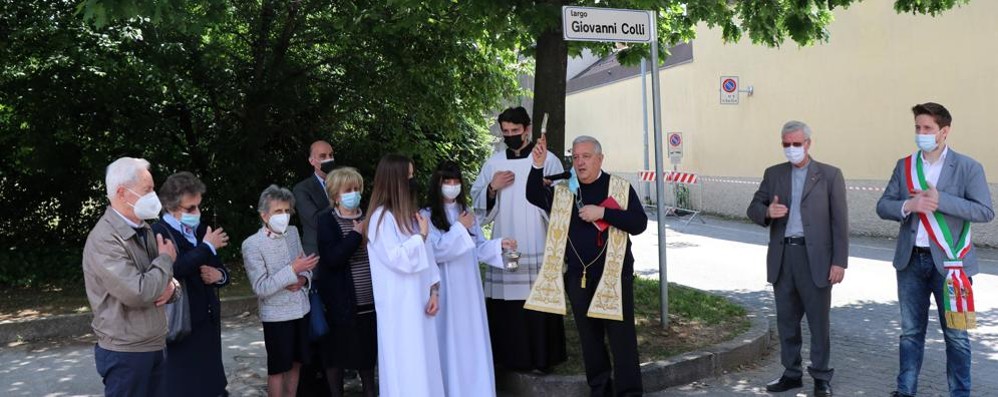 Il prevosto monsignor Bruno Molinari mentre benedici largo Colli con a fianco il sindaco Rossi, don De Col e i familiari di Colli ( foto Volonterio)