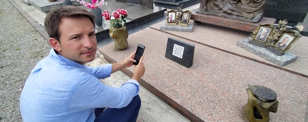 Davide Vago, titolare delle pompe funebri Lanzani e dell'agenzia funebre online funeraliecremazioni, fotografa il QR code sulla tomba dei nonni a Seveso