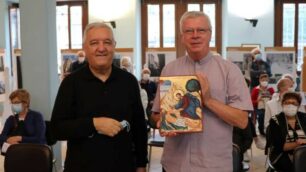 Monsignor Bruno Molinari consegna il primo premio "Casa della Carità" a don Graziano De Col, direttore del Piccolo Cottolengo Don Orione di Seregno