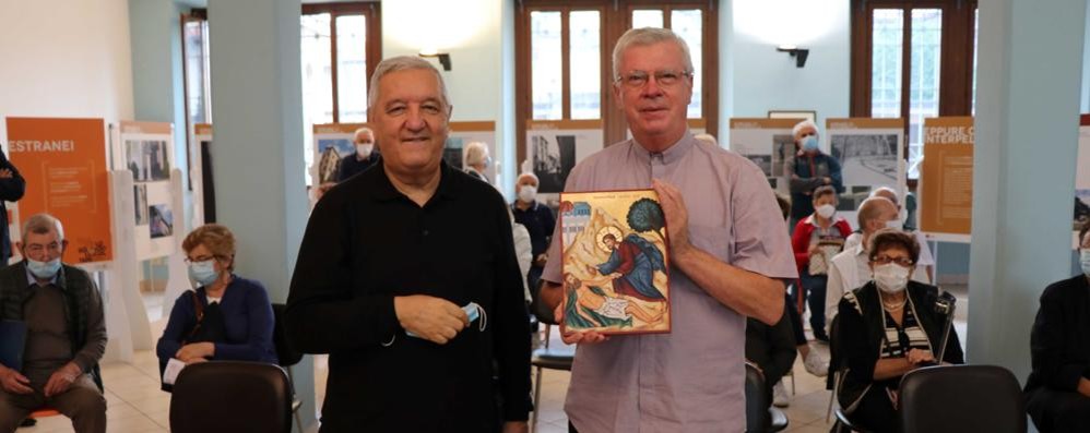 Monsignor Bruno Molinari consegna il primo premio "Casa della Carità" a don Graziano De Col, direttore del Piccolo Cottolengo Don Orione di Seregno