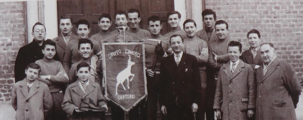 La prima foto storico del Gruppo Camosci del 1957,accanto al gagliardetto Luigi Leone in fondatore, in alto a sinistra il monzese don Giuliano Sala assistente nel 1956 dell'oratorio San Rocco di Seregno