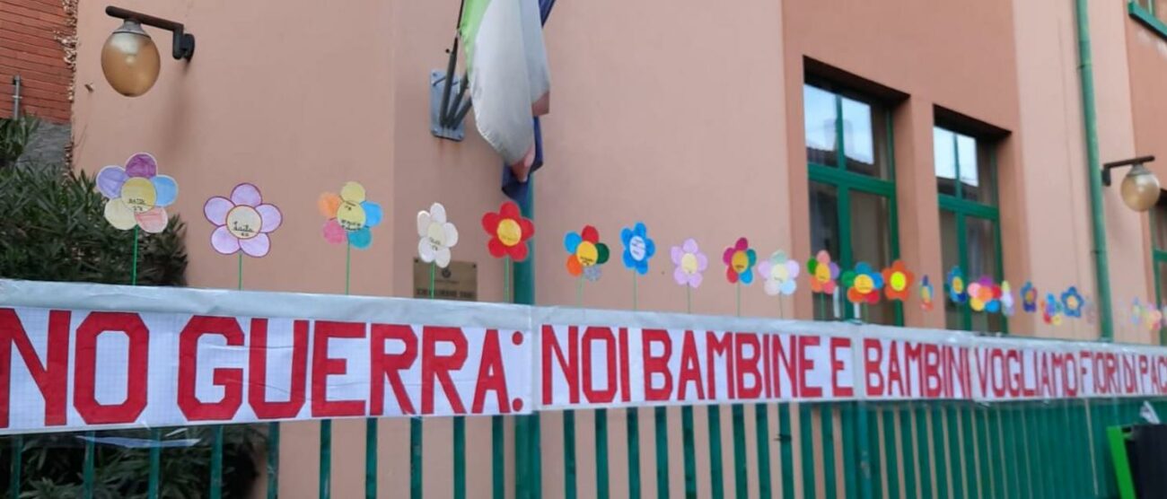 Il cartellone e i fiori colorati per dire no alla guerra