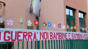 Il cartellone e i fiori colorati per dire no alla guerra