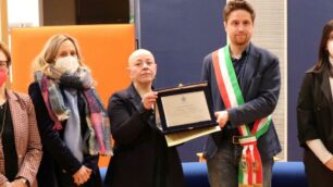 La volontaria Silvia Redigolo riceve la targa "premio Mimosa" dalle mani del sindaco Rossi di Seregno